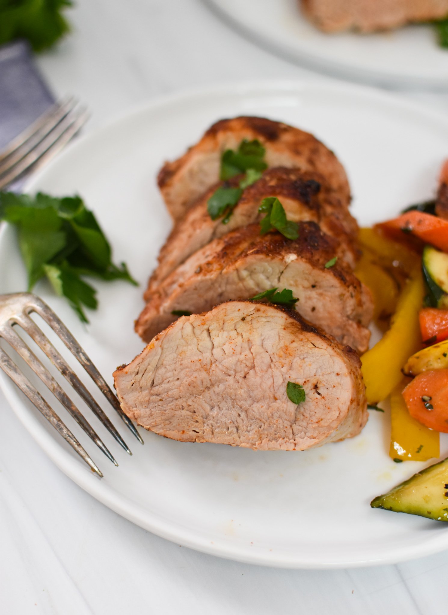 Air Fryer Pork Tenderloin on a white plate with a fork.