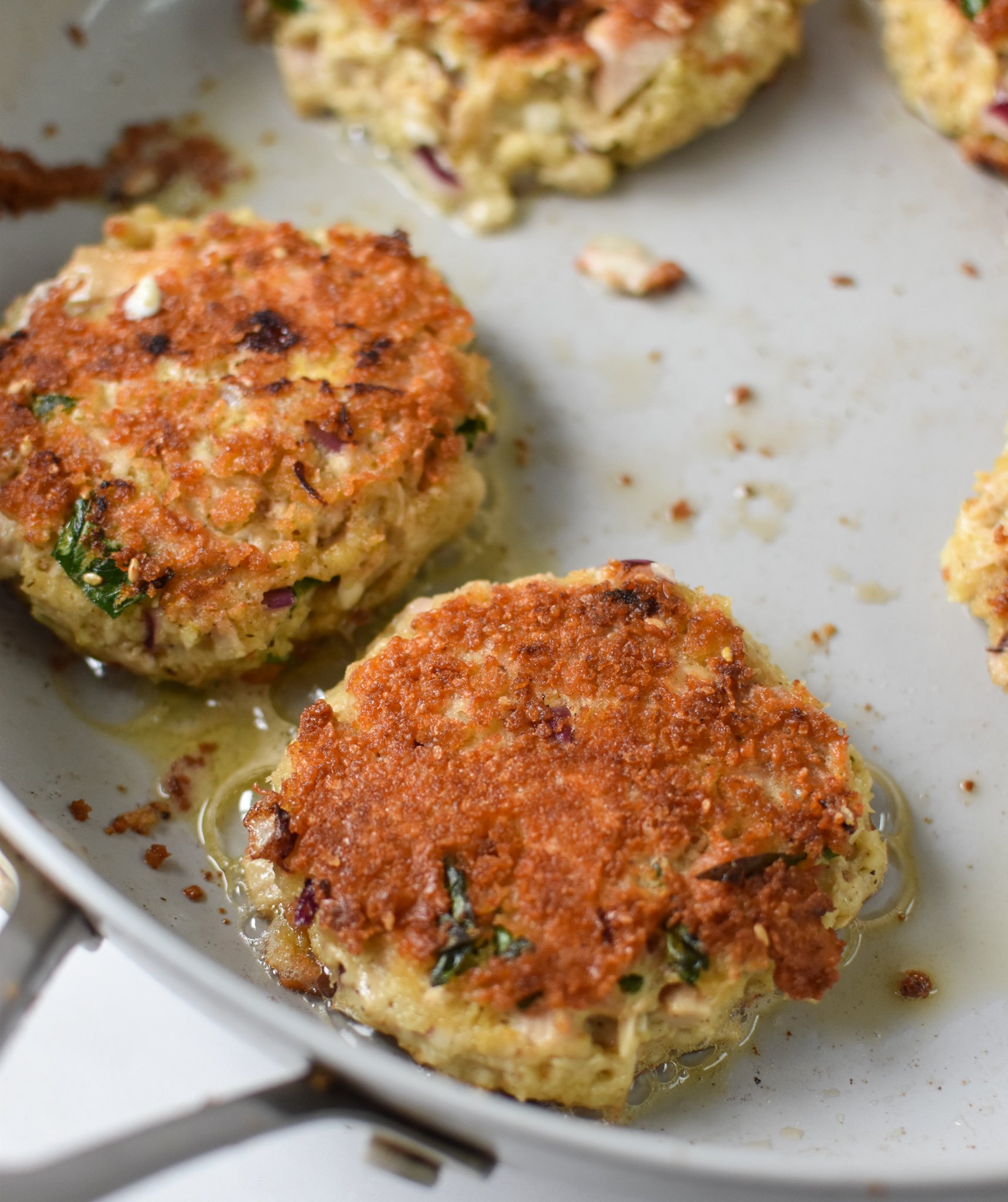 Mediterranean Tuna Patties Recipe tuna cakes in a skillet.