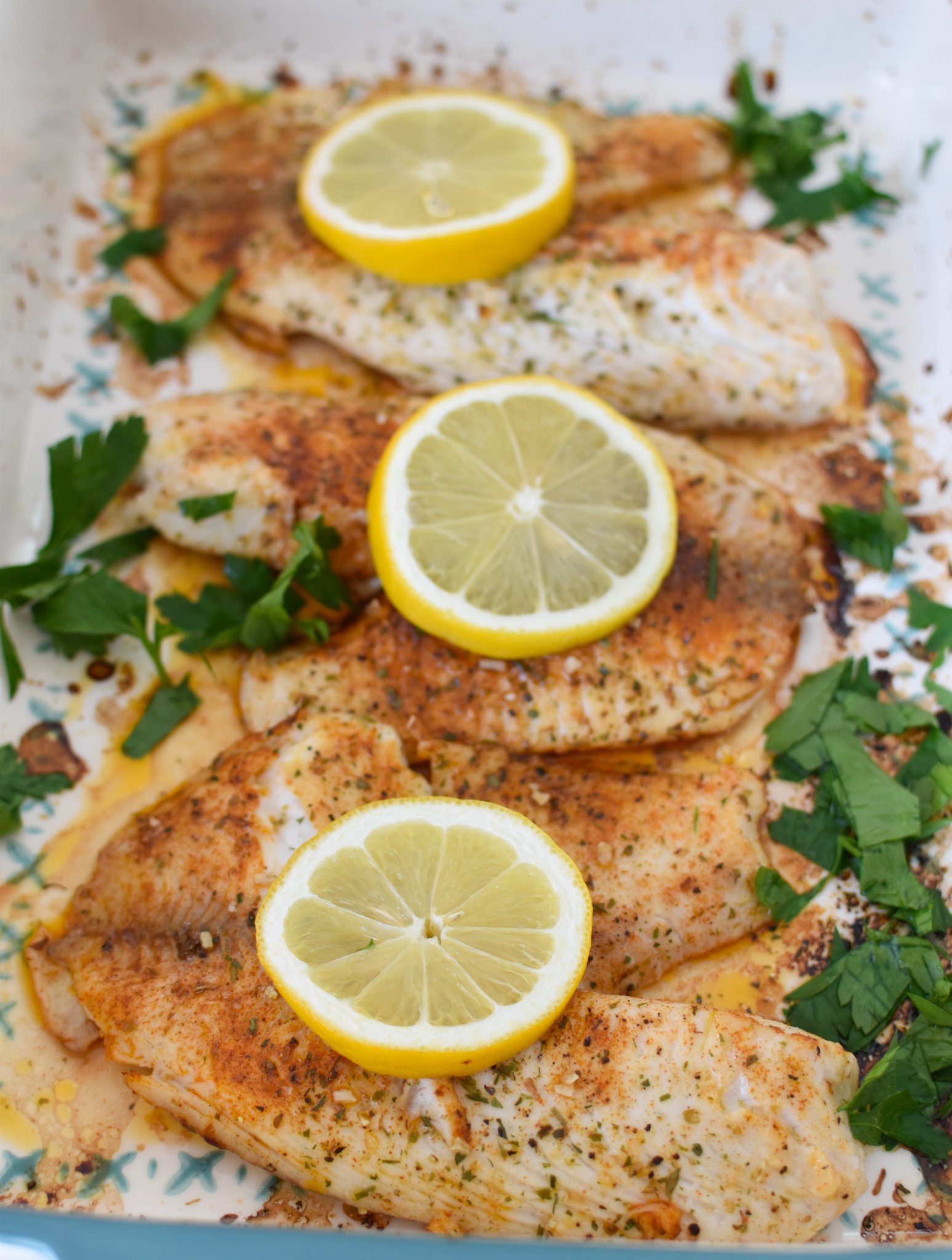 Greek Baked Tilapia in a pan with lemons. 