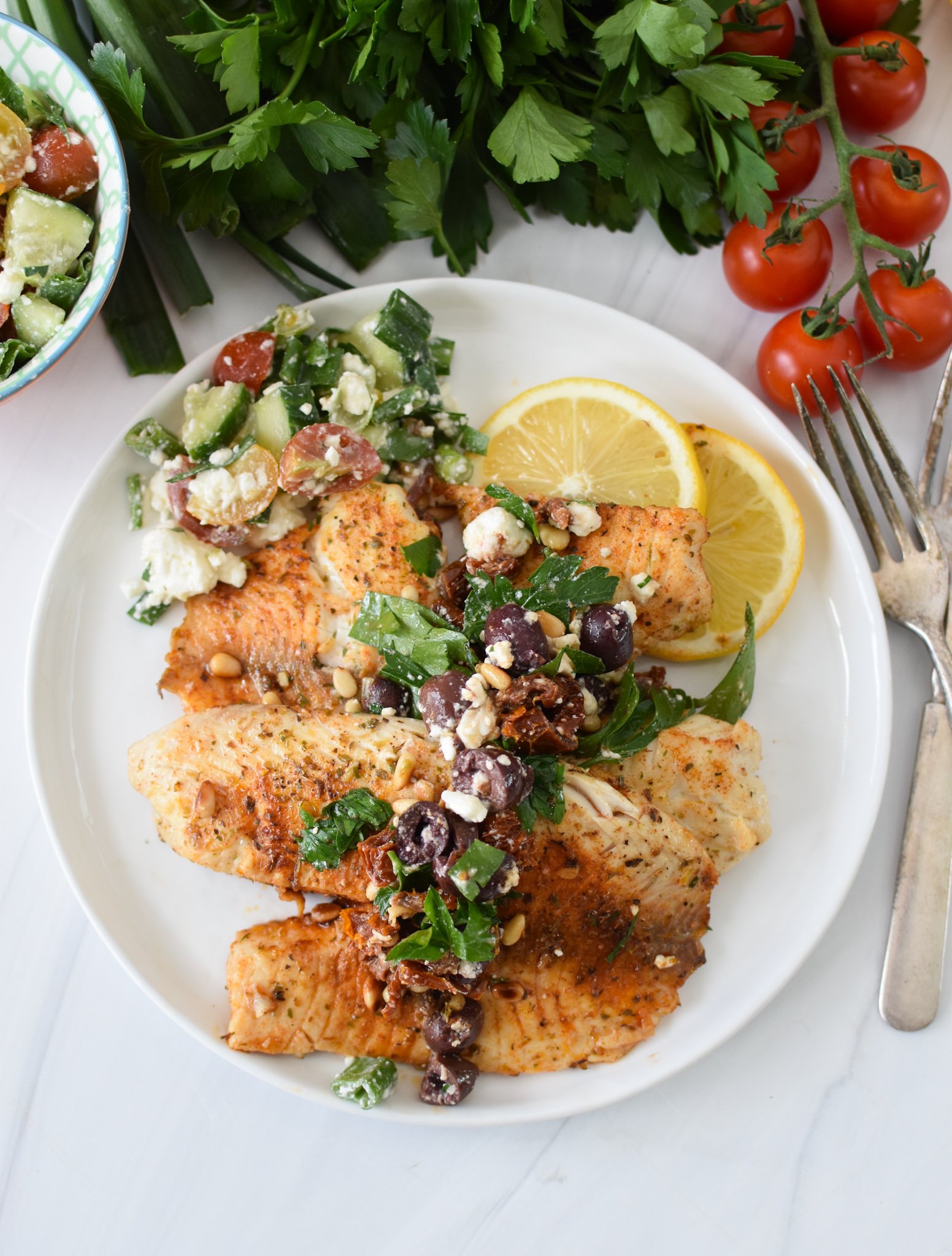 Greek Baked Tilapia with olives and a salad.
