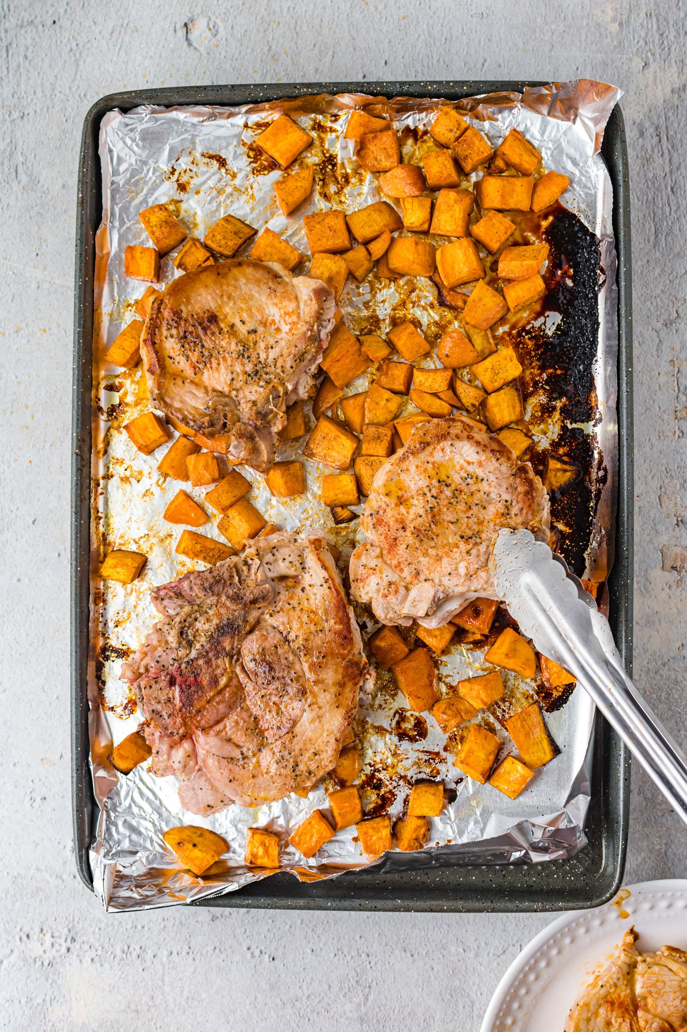 Maple Bourbon Pork Chops Recipe with tongs.