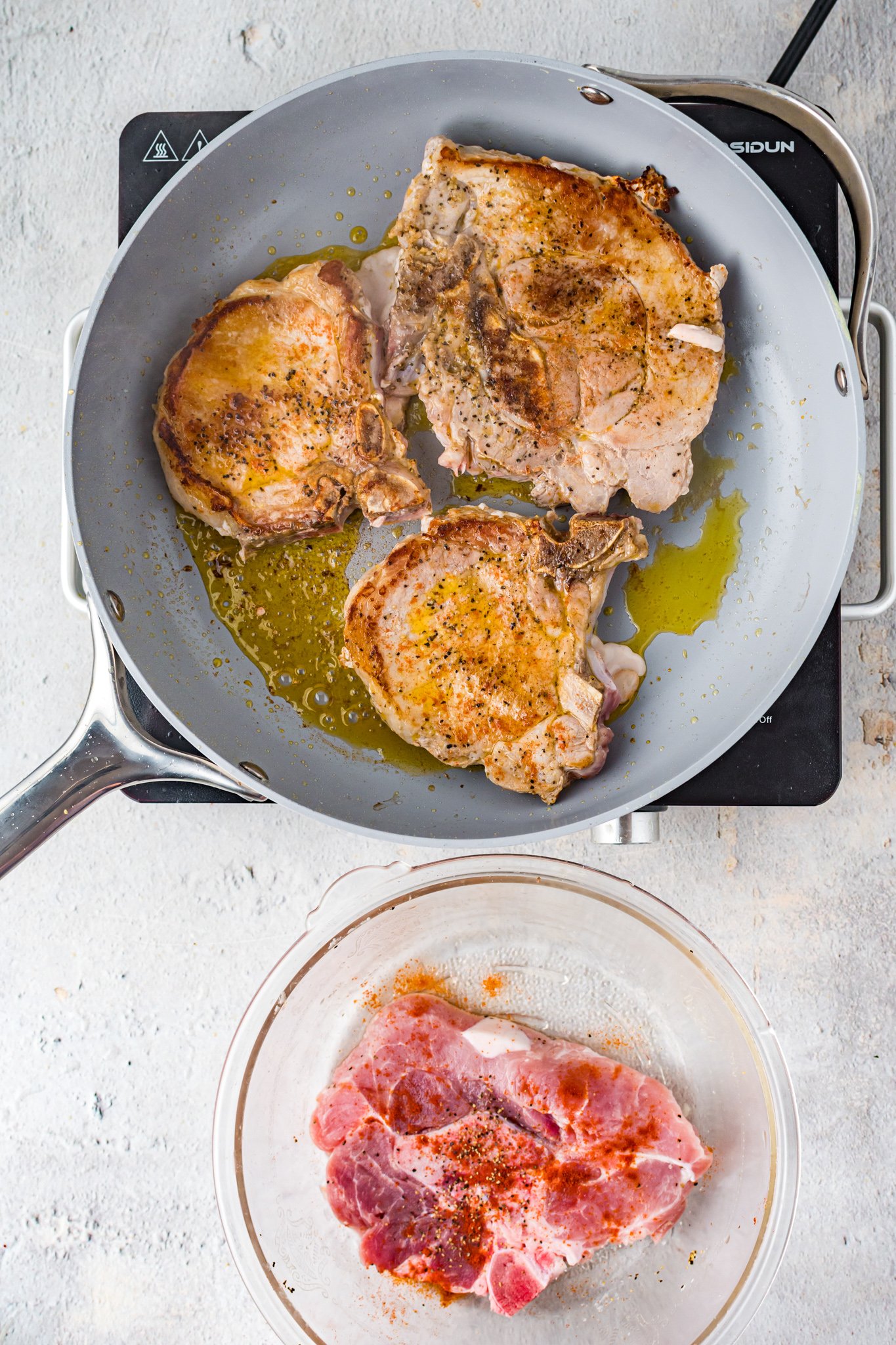 Maple Bourbon Pork Chops Recipe pork chops in a skillet.
