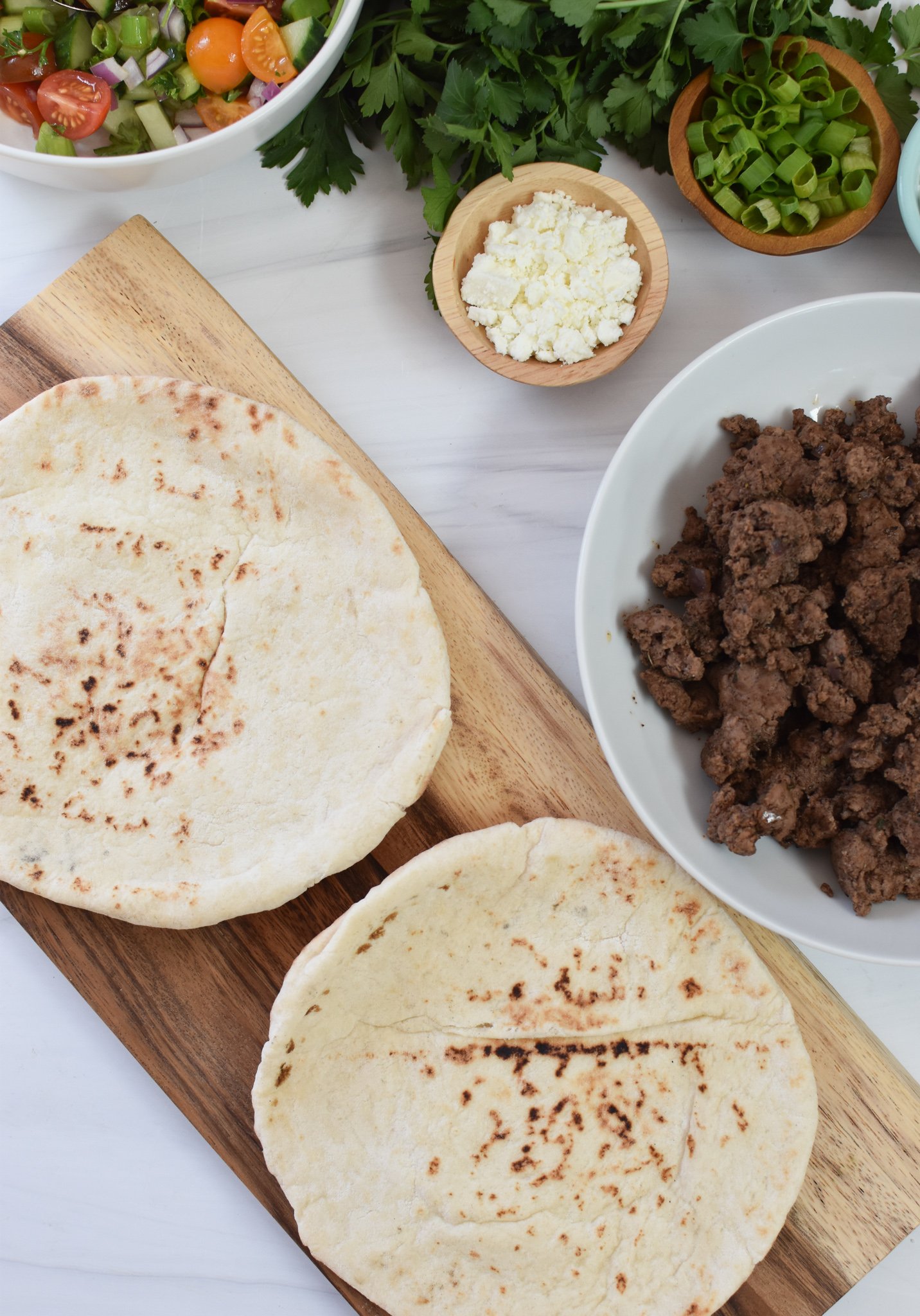 Spiced Ground Lamb Pita Recipe pitas on a cutting board. 