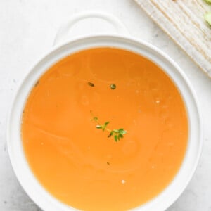 Homemade Chicken Broth in a white bowl.