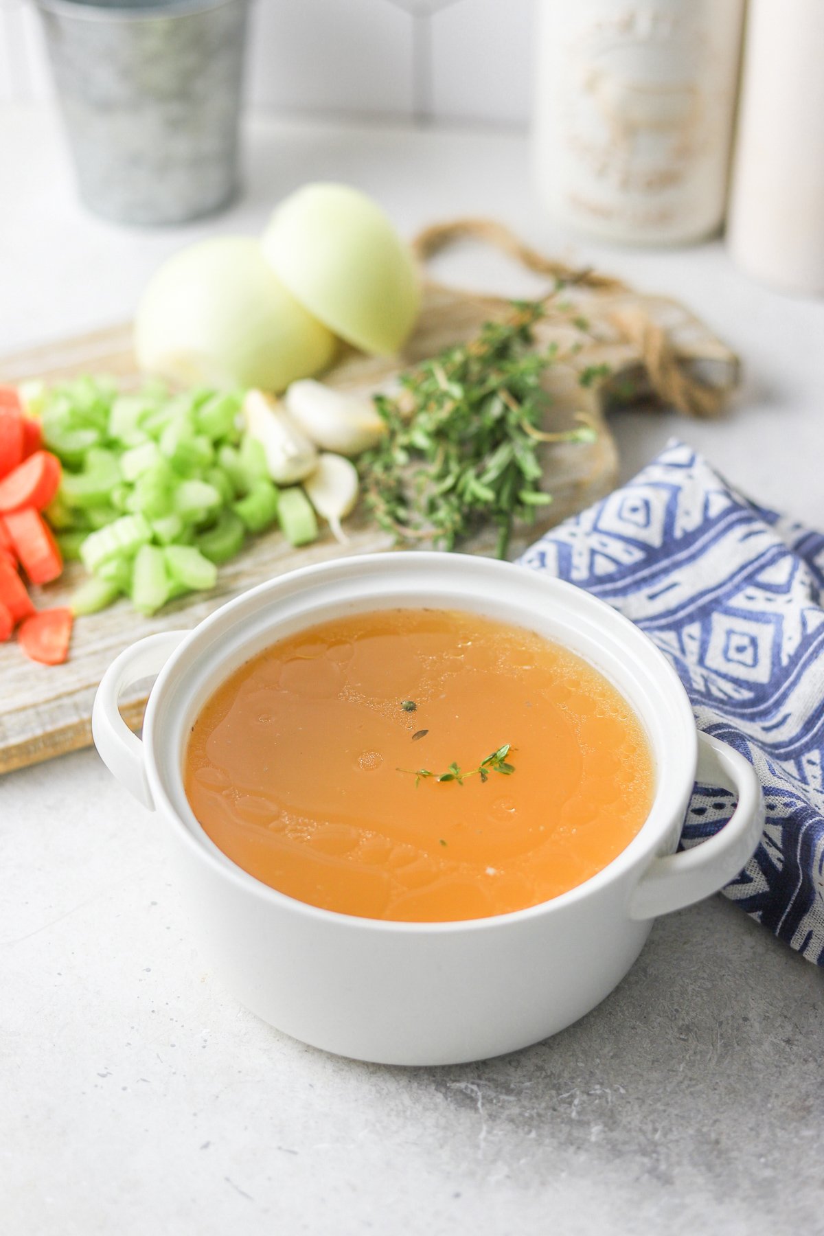 Homemade Chicken Broth with a blue napkin.