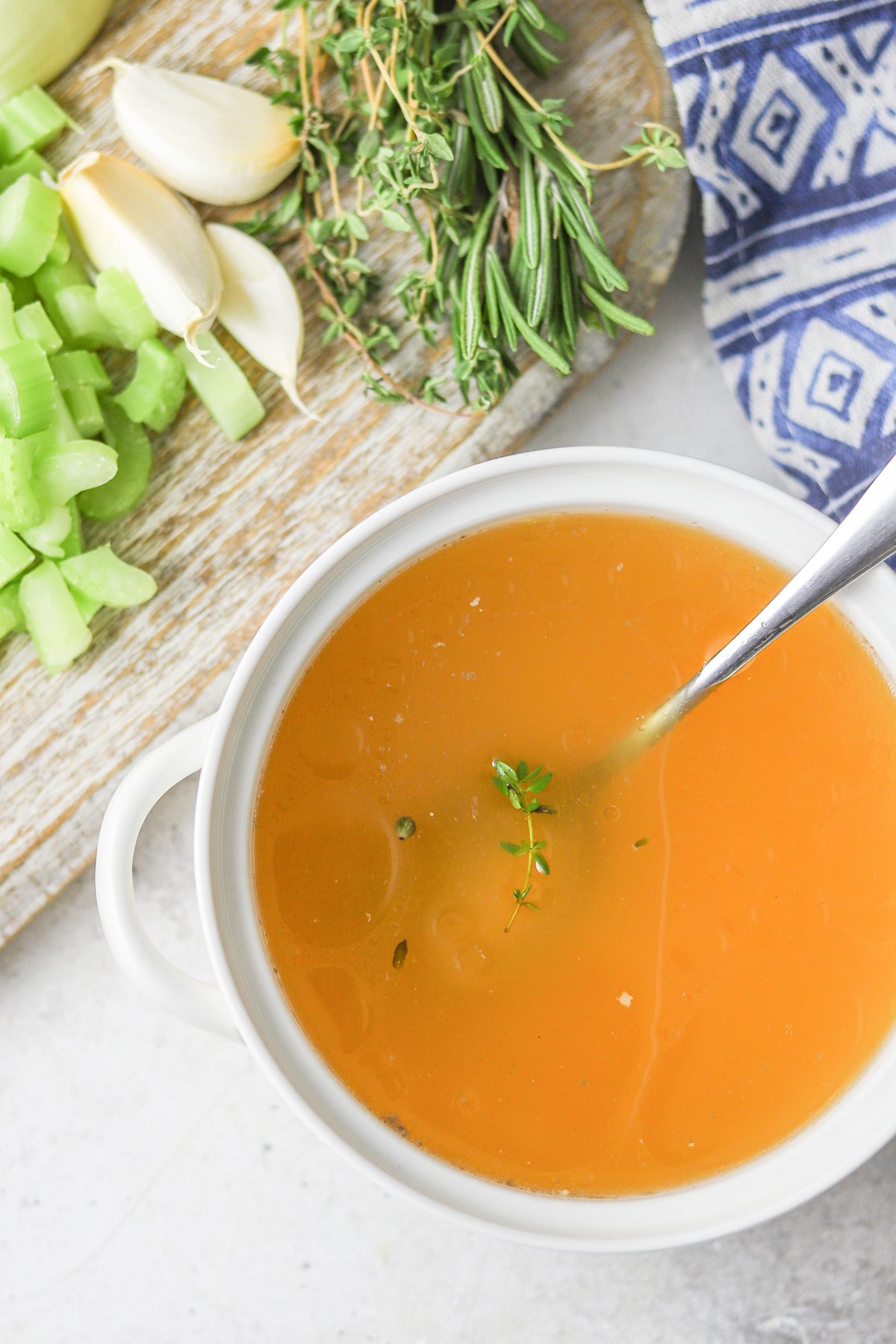 Homemade Chicken Broth in a white bowl with a spoon. 