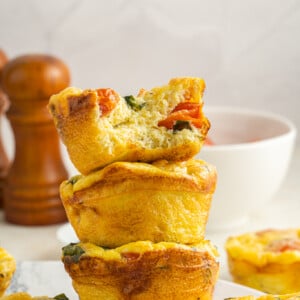 Caprese Egg Muffins stacked on a plate.