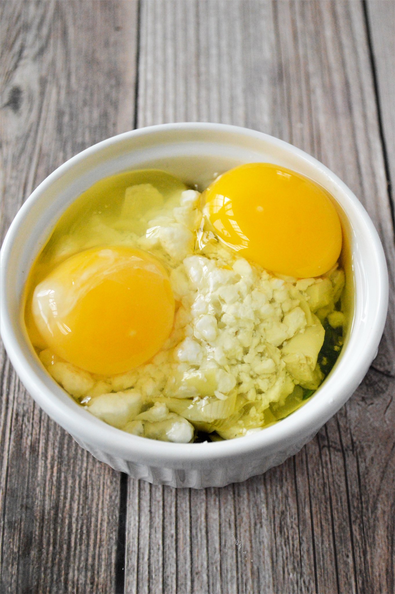 Greek Baked Eggs eggs on top of the feta cheese.