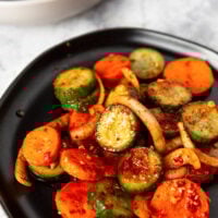 Quick Korean Cucumber Kimchi in a black dish.,