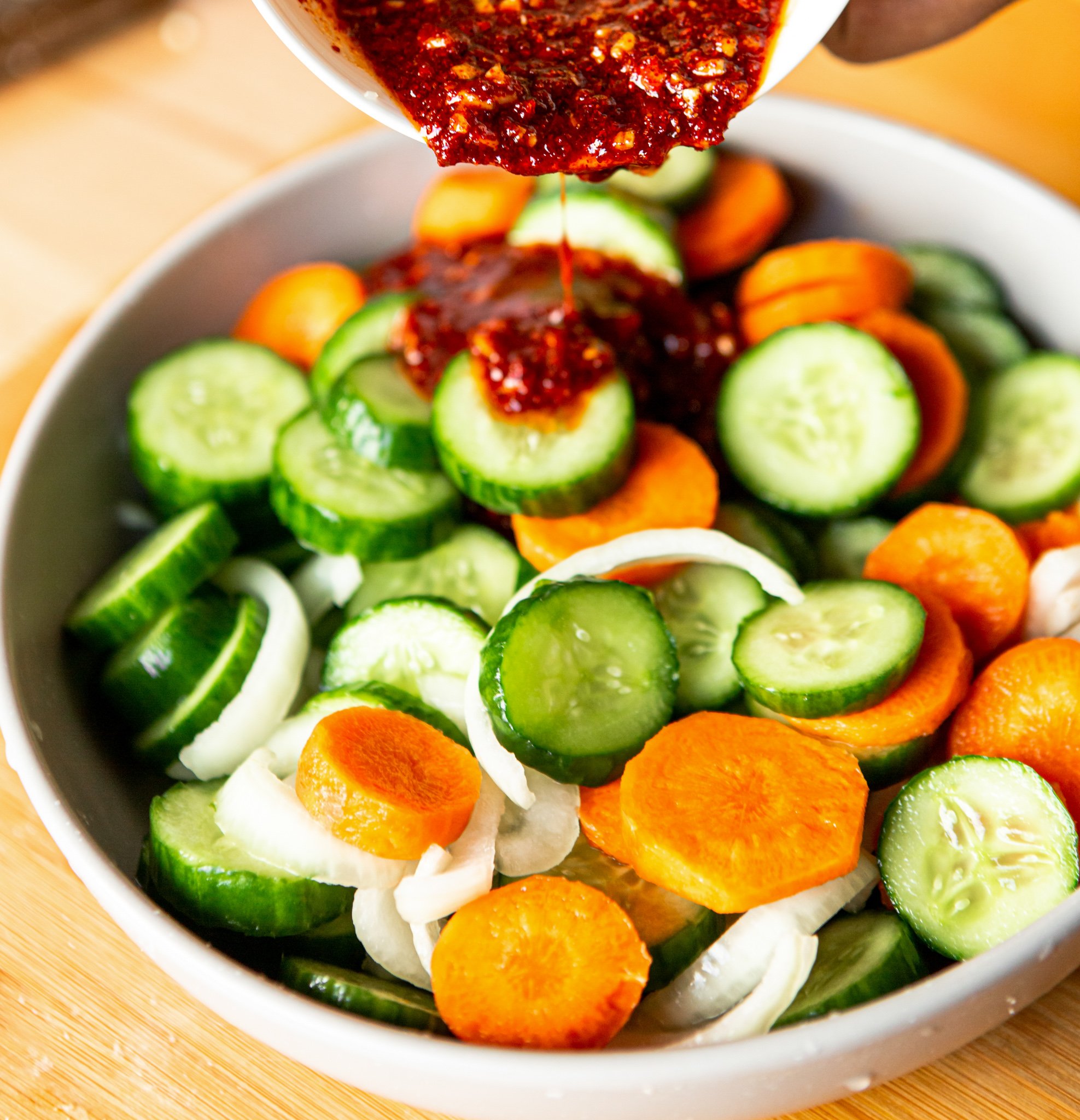 Quick Korean Cucumber Kimchi sauce going into bowl.