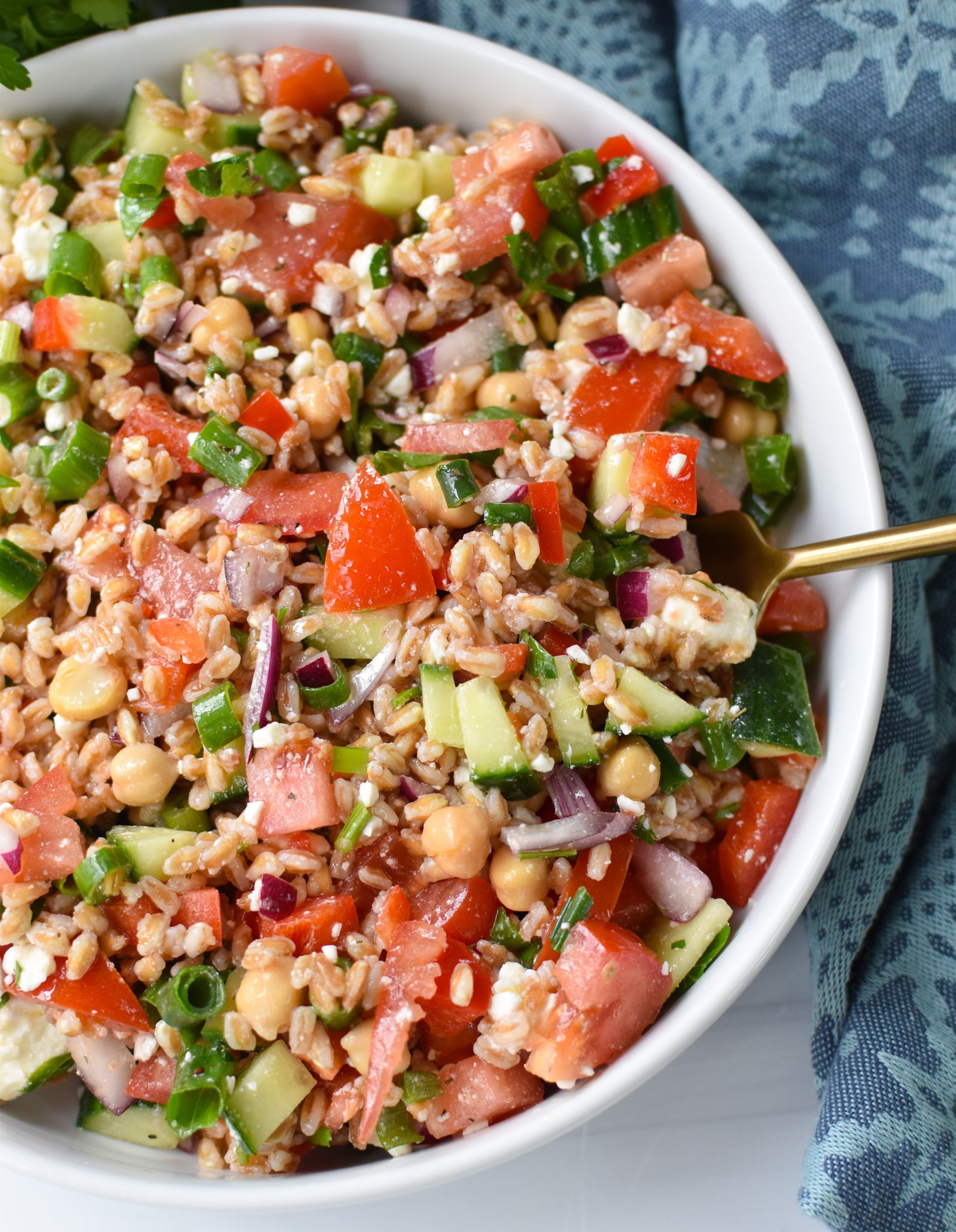 Mediterranean Farro Salad with a gold spoon.