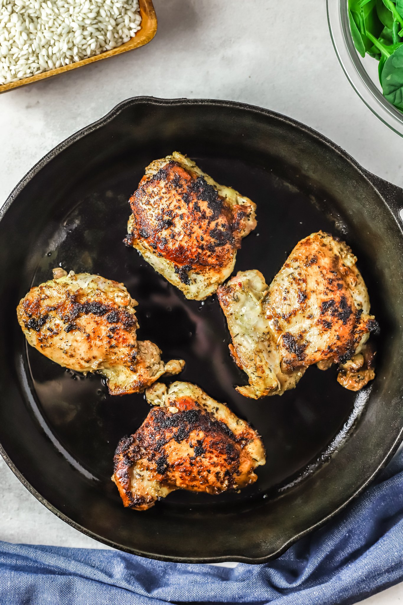 Oven Baked Chicken Thighs with Risotto seared chicken in skillet. 