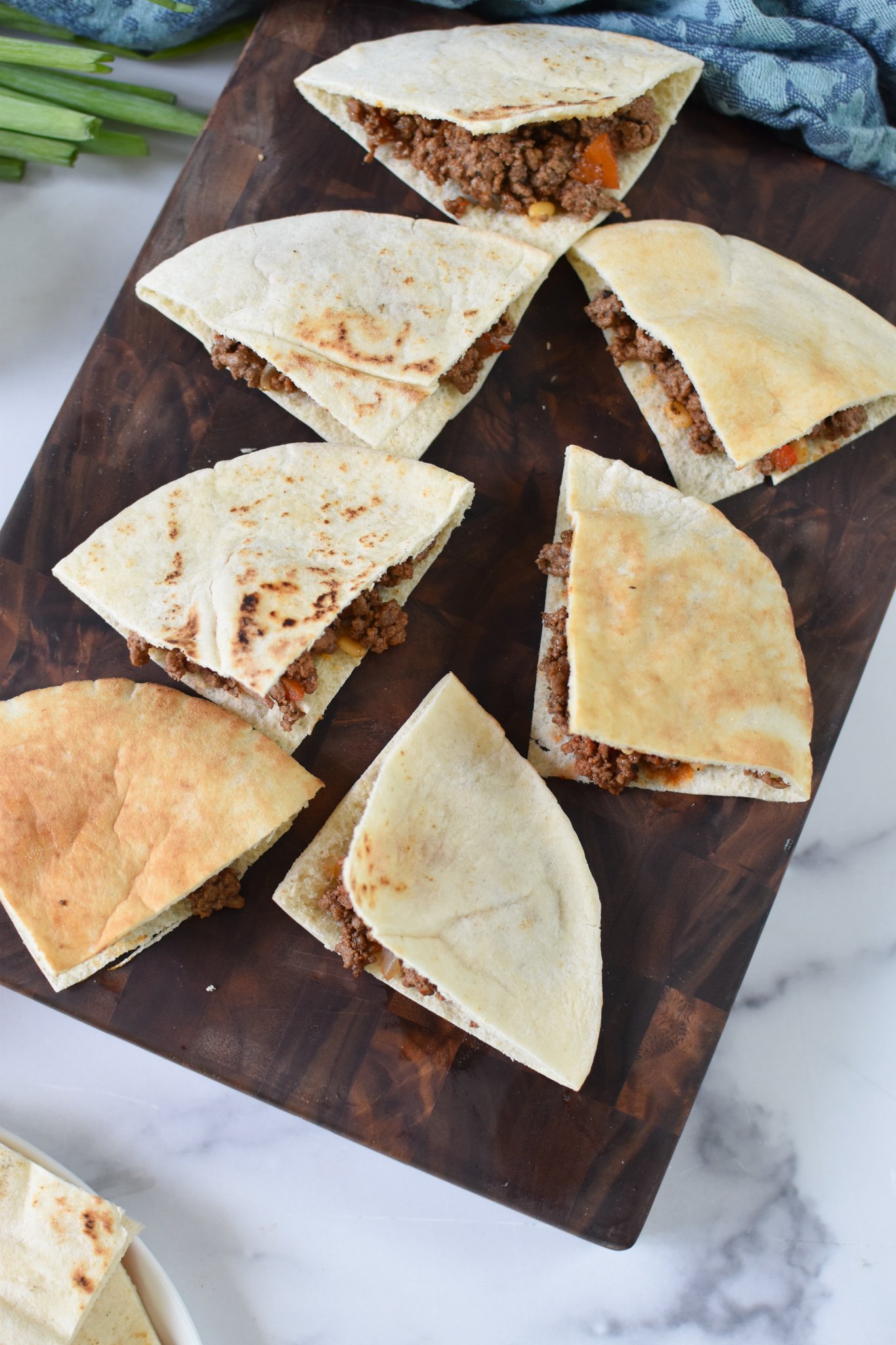 Lebanese Meat Stuffed Pitas pita on a cutting board. 