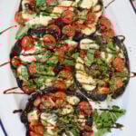 Caprese Stuffed Portobello Mushrooms with balsamic drizzle on a white platter.