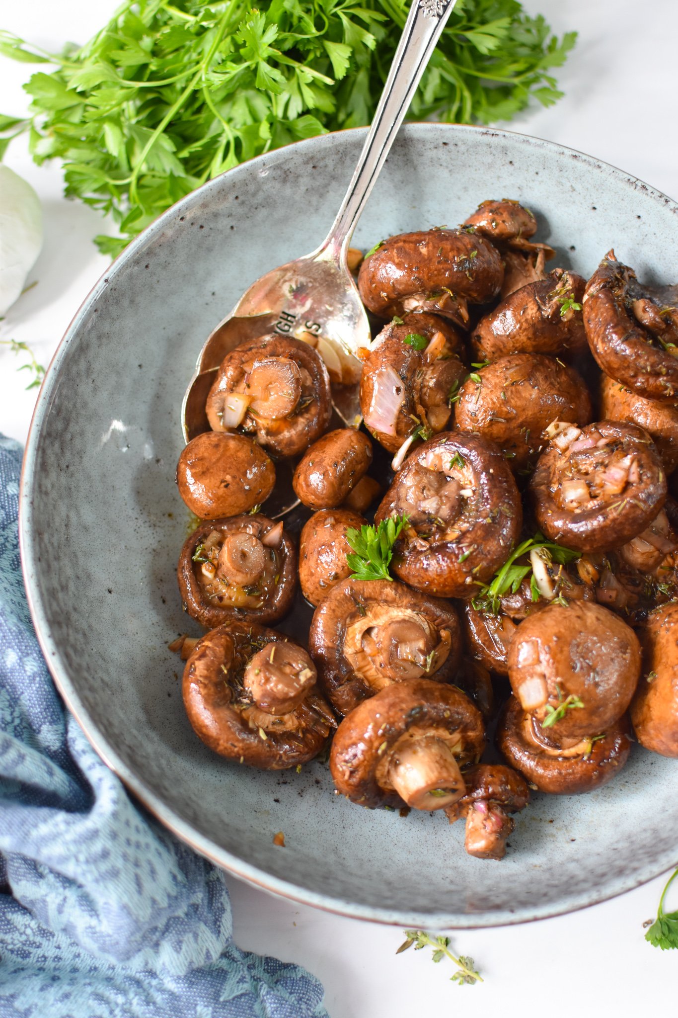 Roasted Balsamic Mushrooms with spoon in blue bowl.
