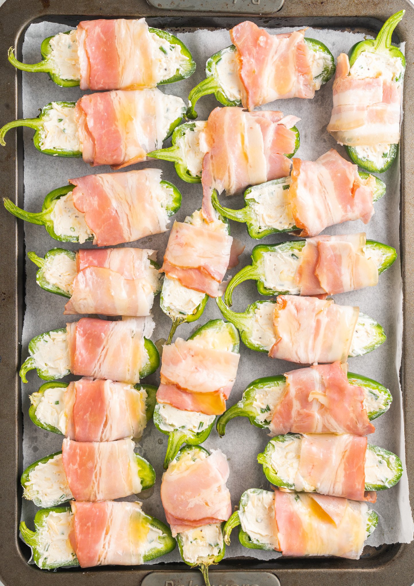 Jalapeño Poppers with Bacon on a baking sheet.