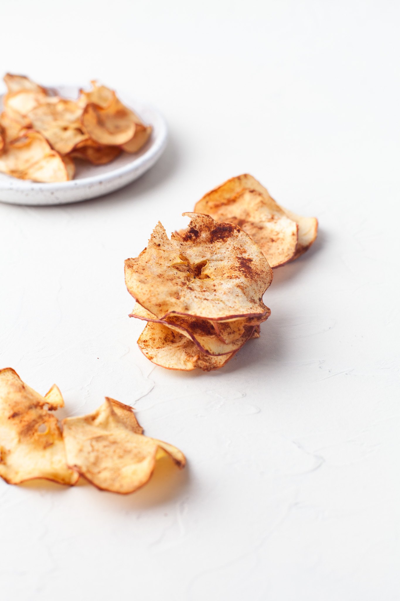 Easy Air Fryer Apple Chips apples on a white table 