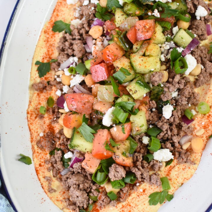 Ground Beef Layered Hummus on a white platter with blue rim.