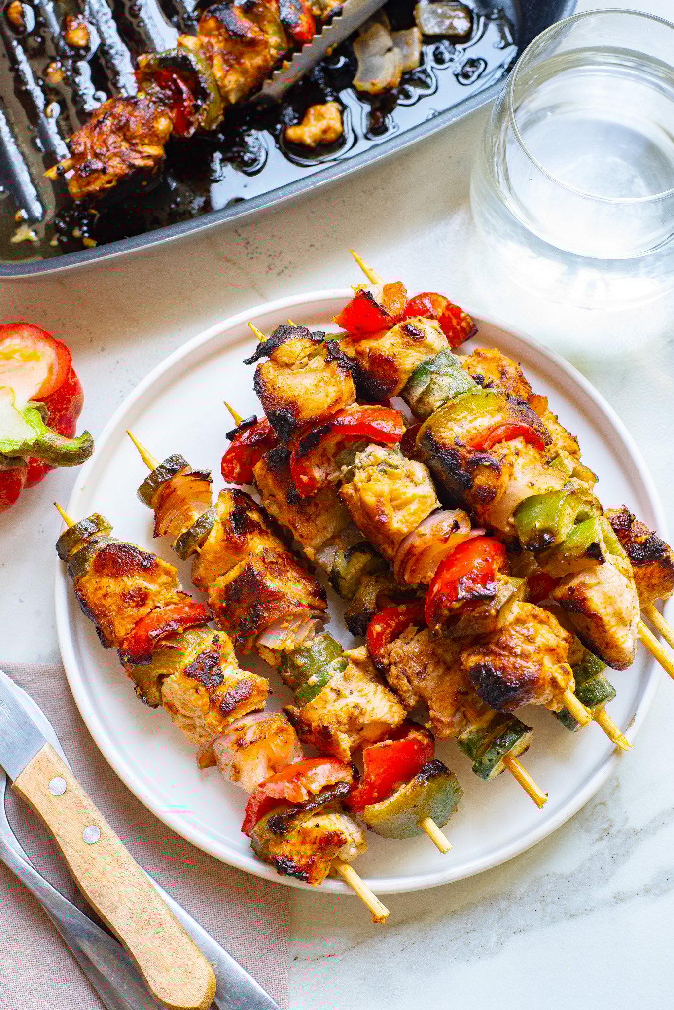 Greek Marinated Chicken Kabobs with Lemon on a white plate. 