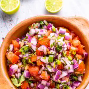 Homemade Pico de Gallo in a tan colored bowl.