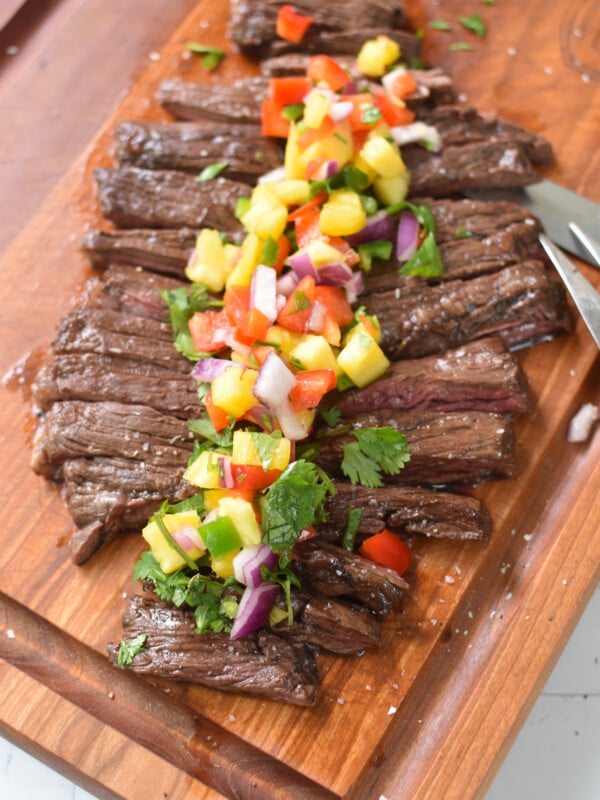 Balsamic Marinated Skirt Steak on a cutting board with a fork and knife.