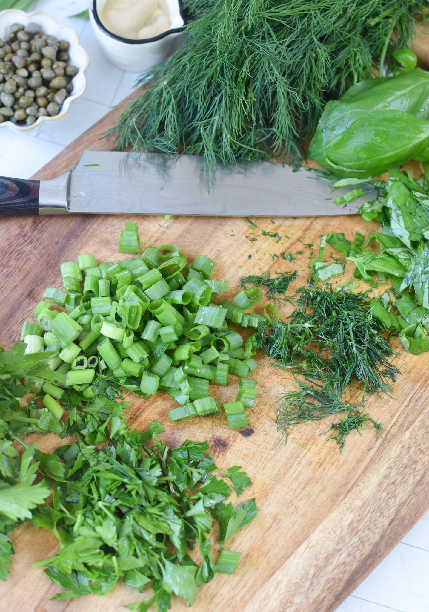 No Mayo Potato Salad herbs on a cutting board. 