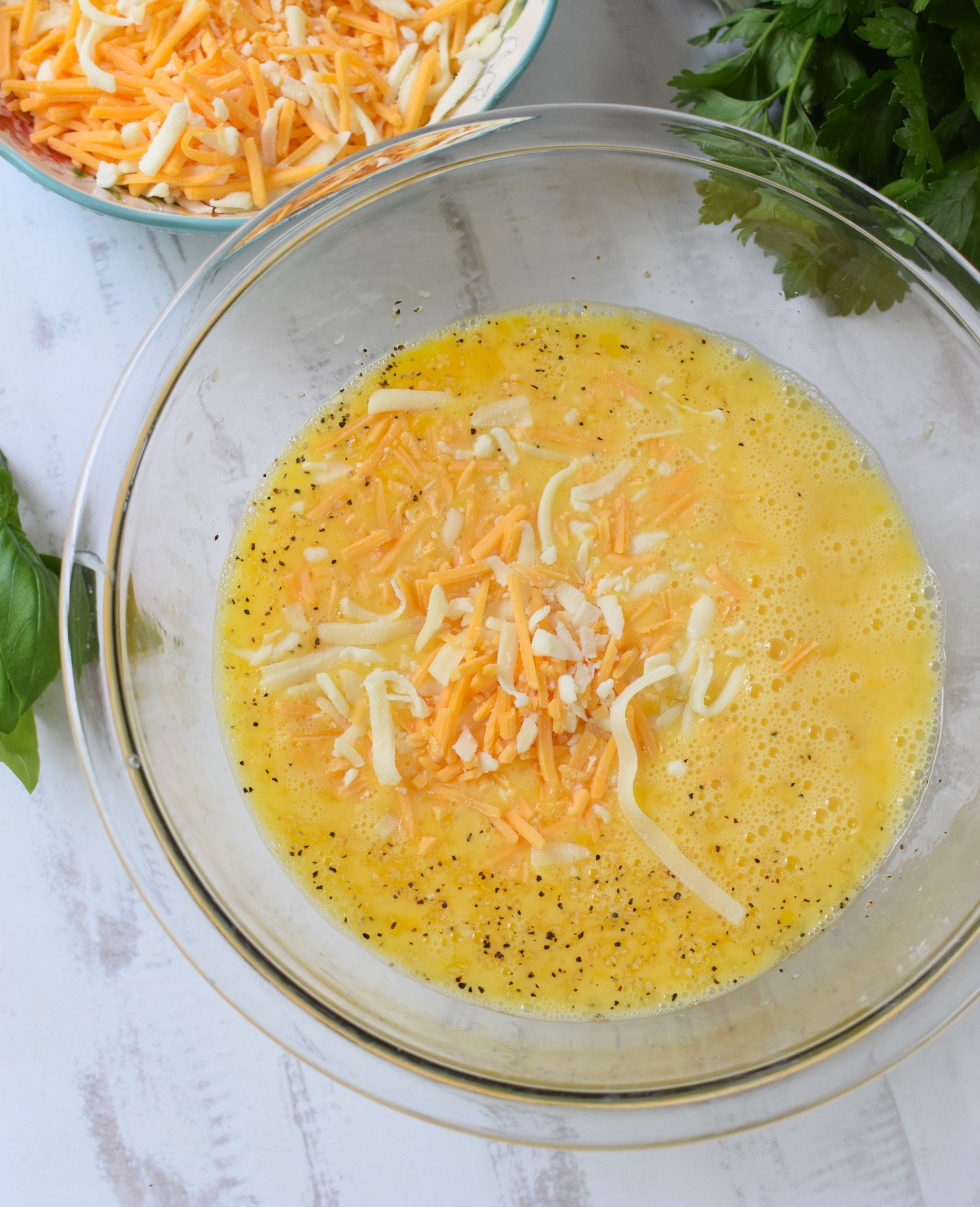 Zucchini Frittata Recipe with cheese and eggs in bowl. 