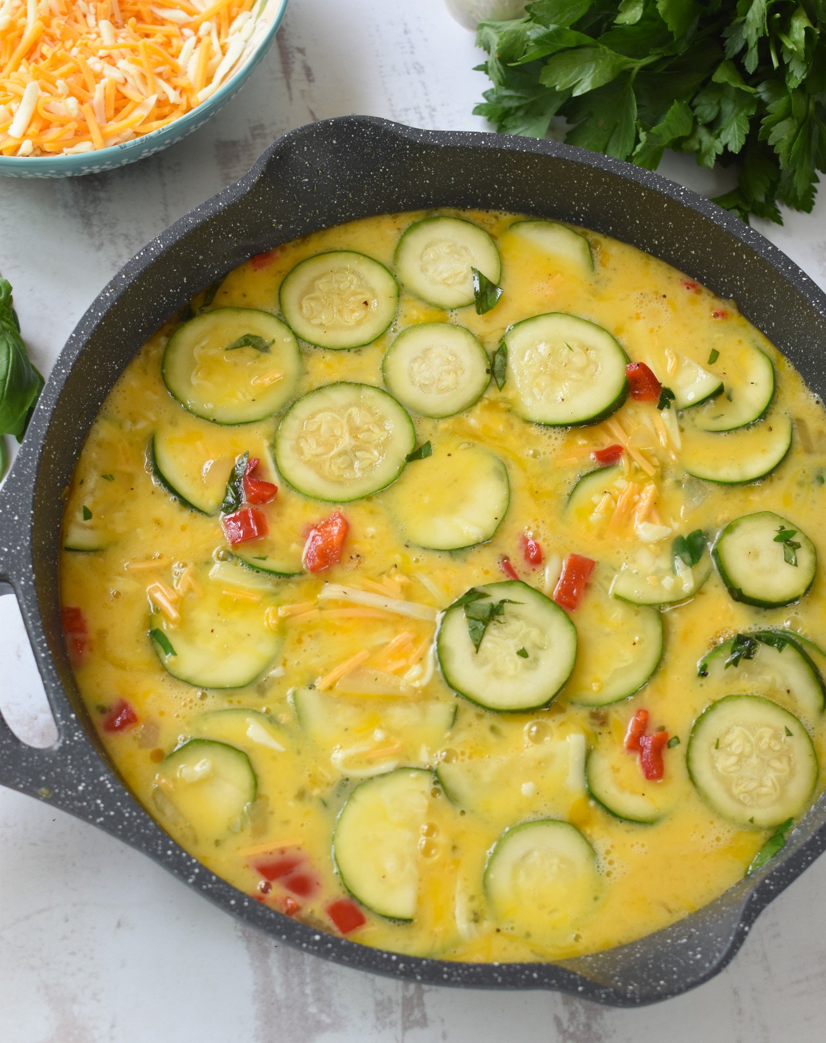 Zucchini Frittata Recipe eggs and vegetables in a skillet.