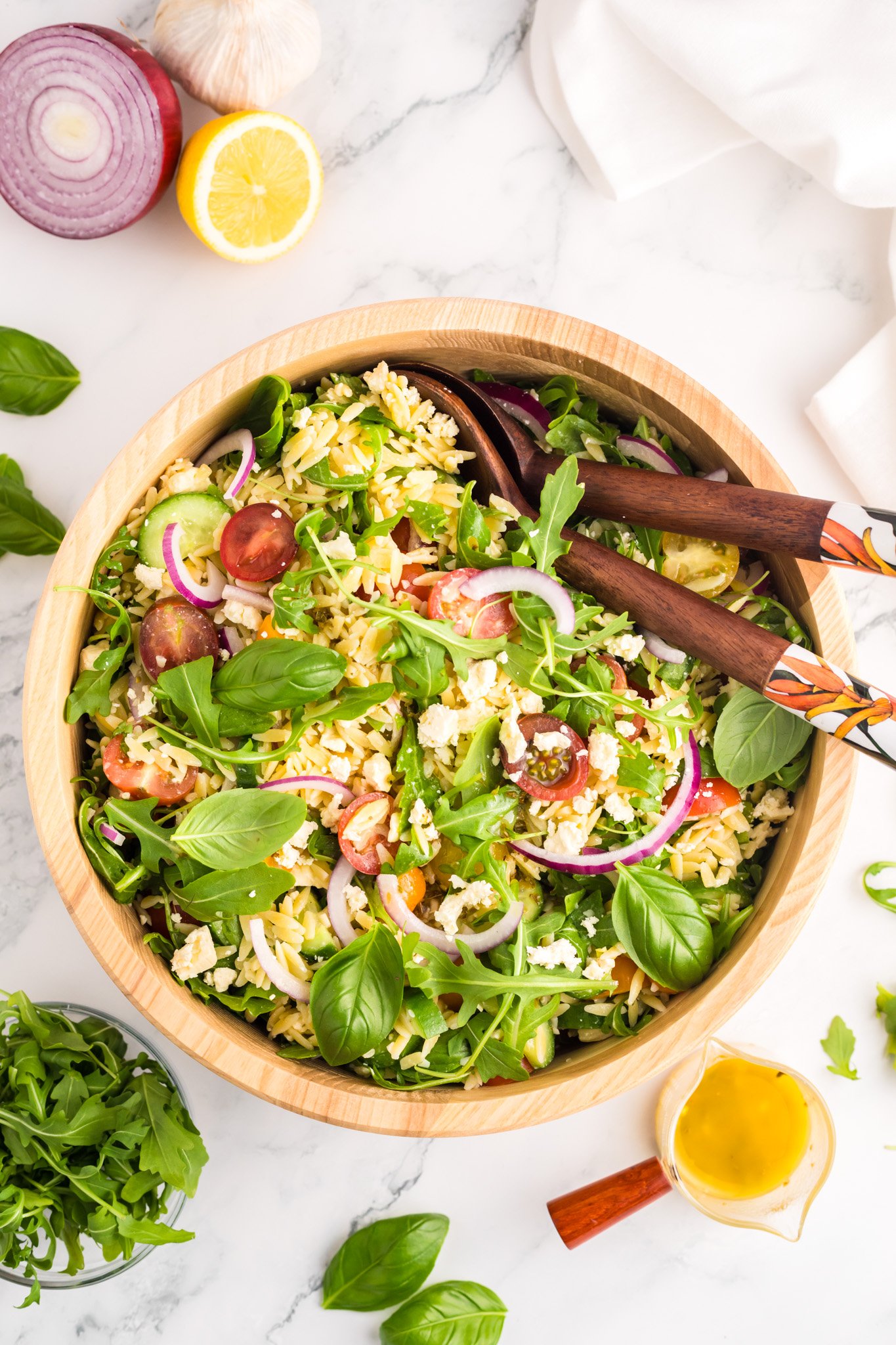 Arugula Orzo Salad with wooden spoons.