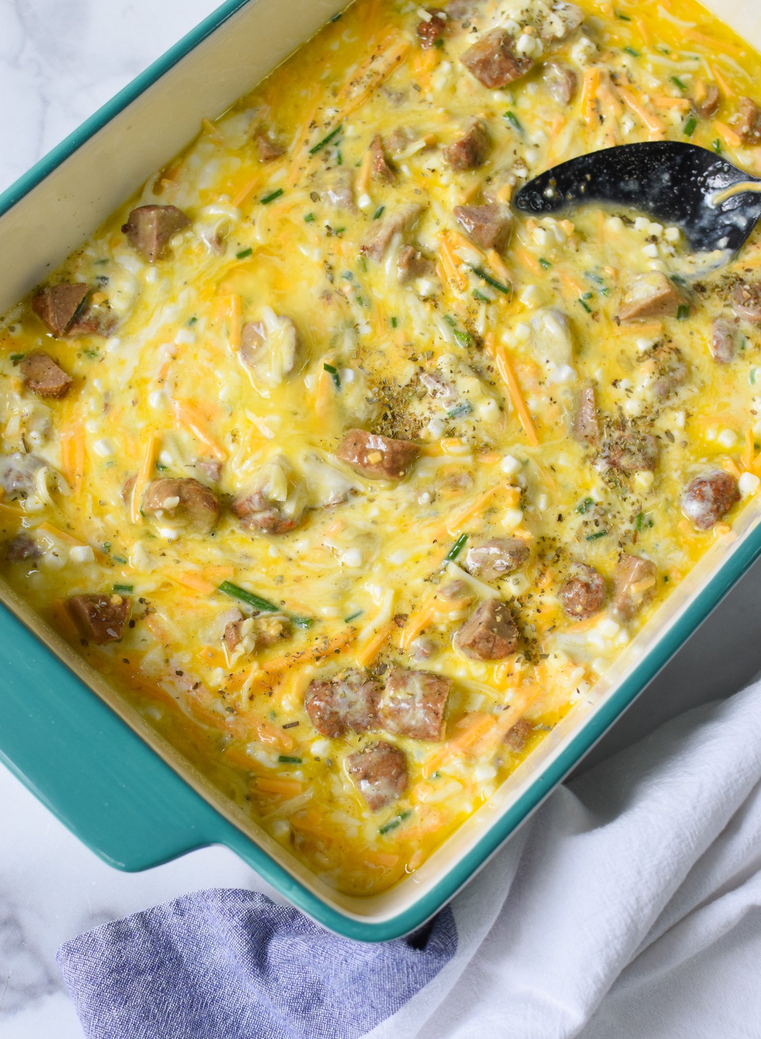 Cheese and Sausage Baked Eggs ingredients in a casserole dish. 