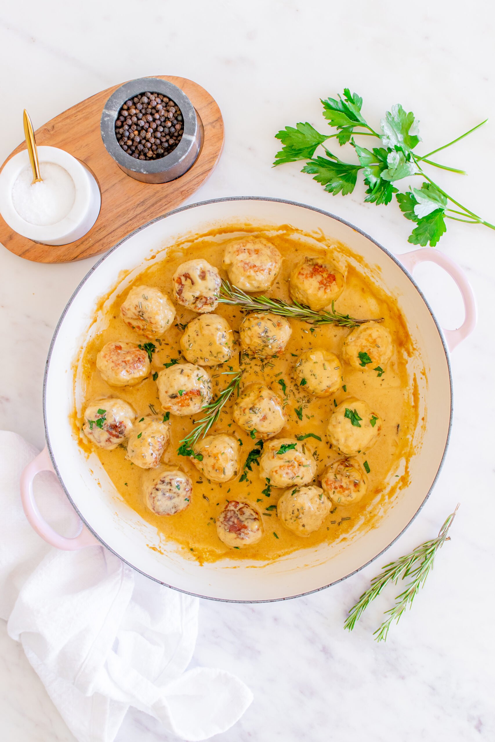 Maple Dijon Turkey Meatballs in a dutch oven with rosemary. 