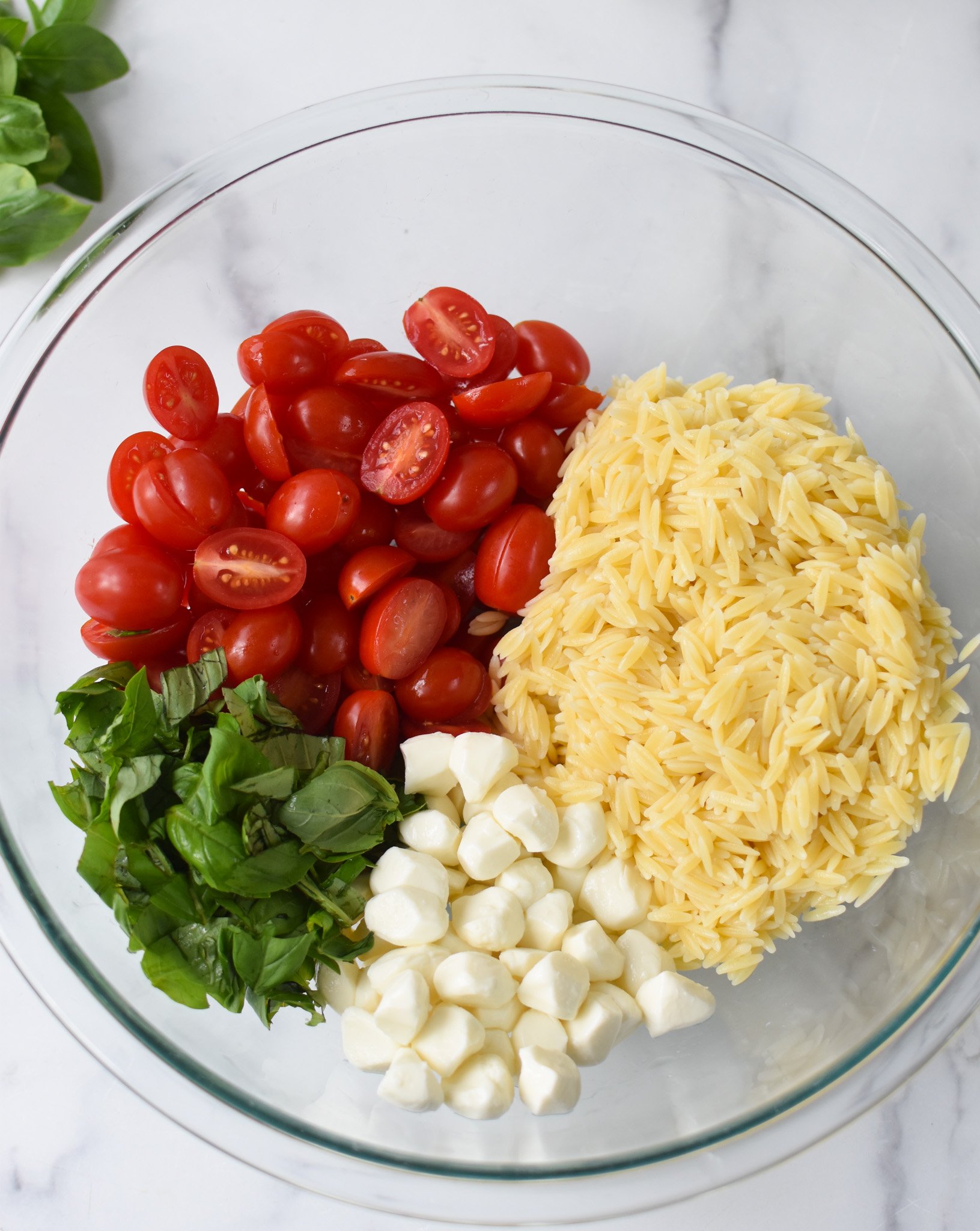 Caprese Orzo Pasta Salad ingredients in a bowl. 
