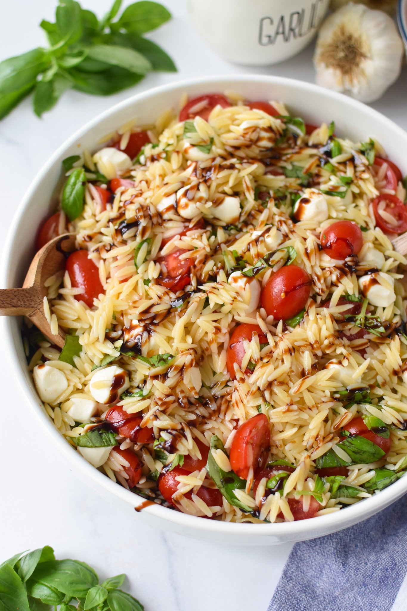 Caprese Orzo Pasta Salad with balsamic in a large bowl.