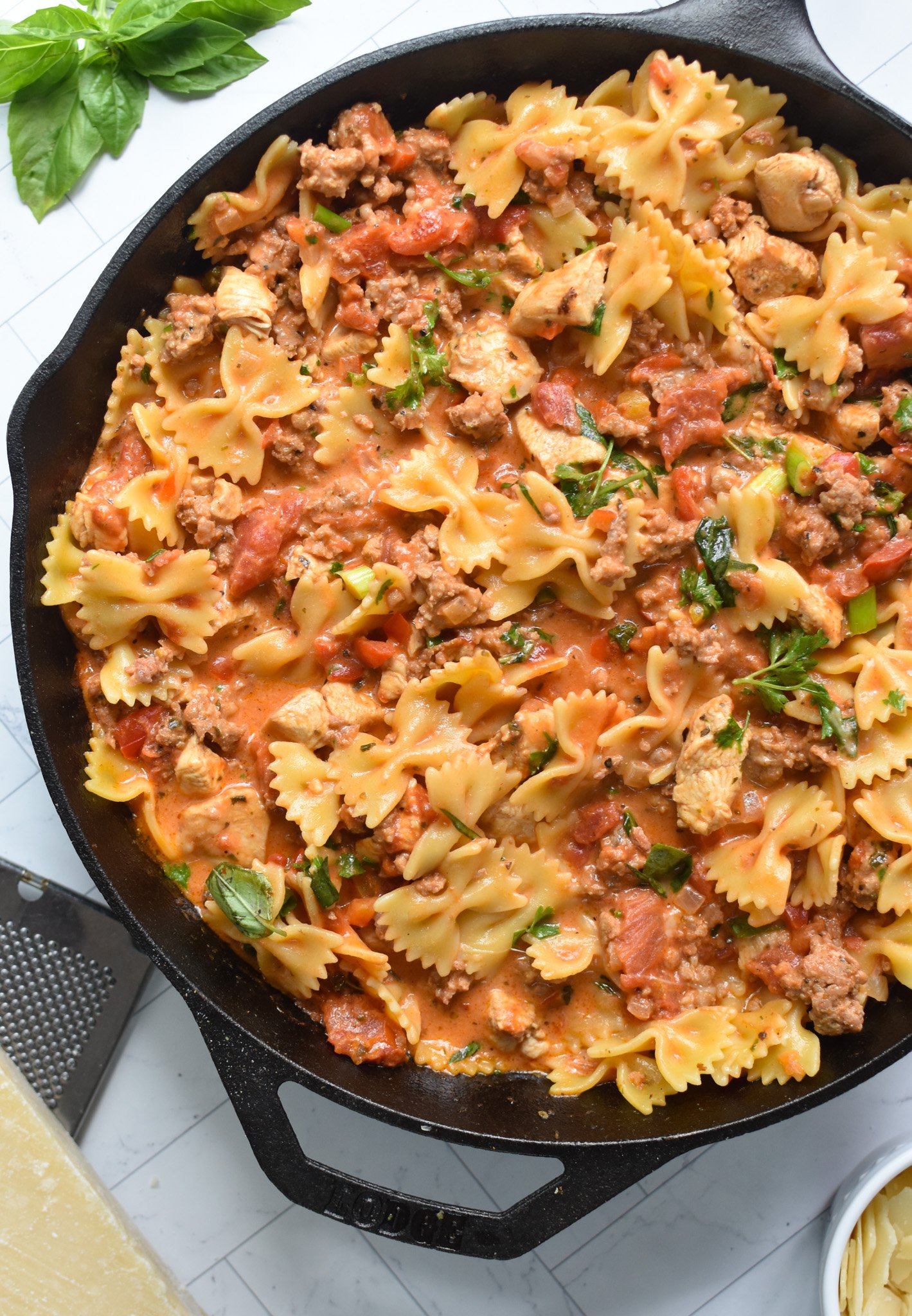 Creamy Chicken and Chorizo Pasta Recipe in black skillet.