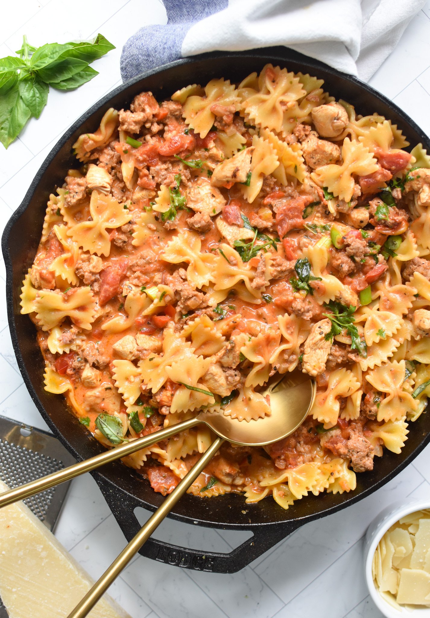 Creamy Chicken and Chorizo Pasta Recipe with gold spoons.