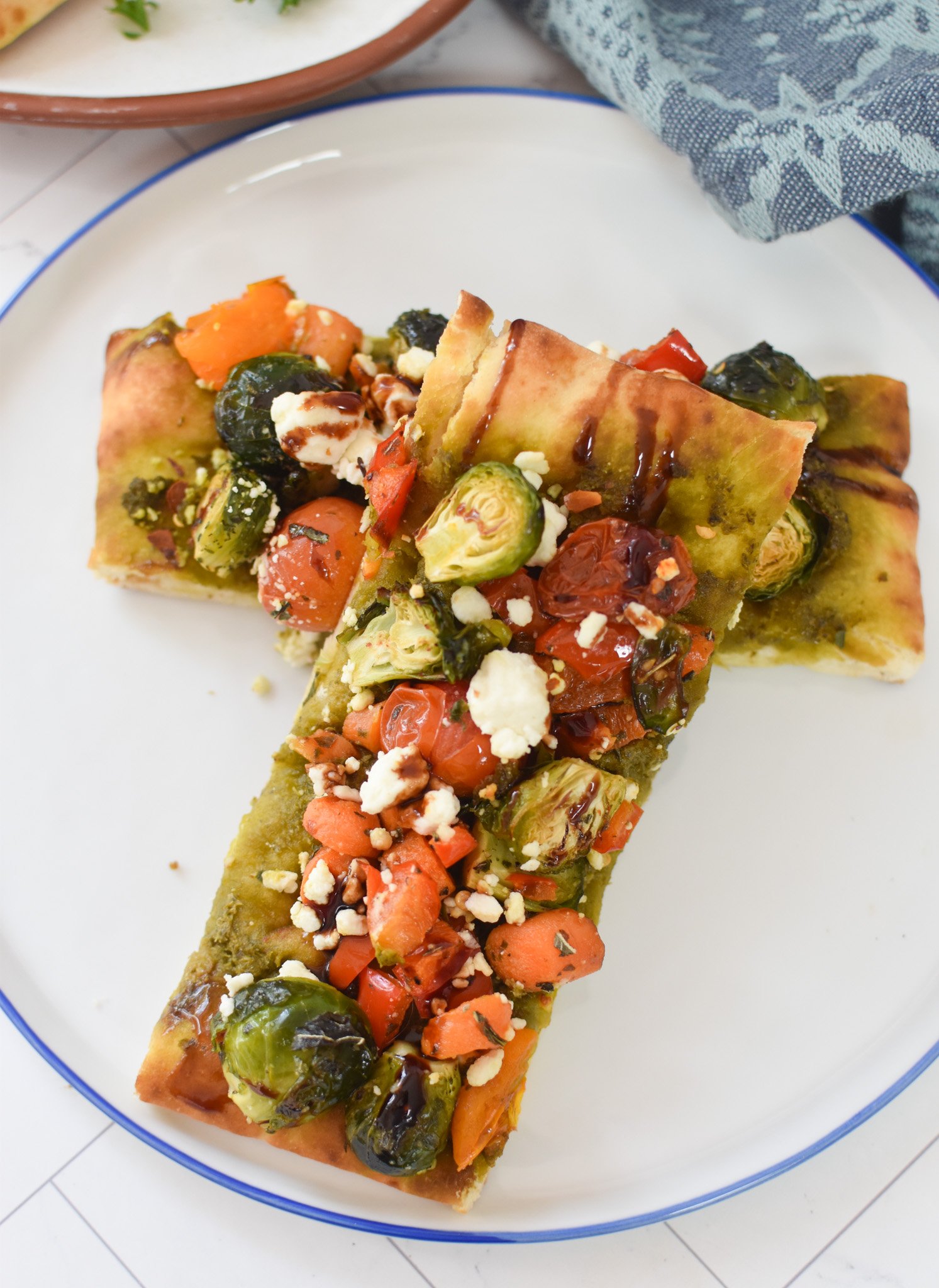 Roasted Vegetable Goat Cheese Flatbread Pizza Recipe on a white plate. 