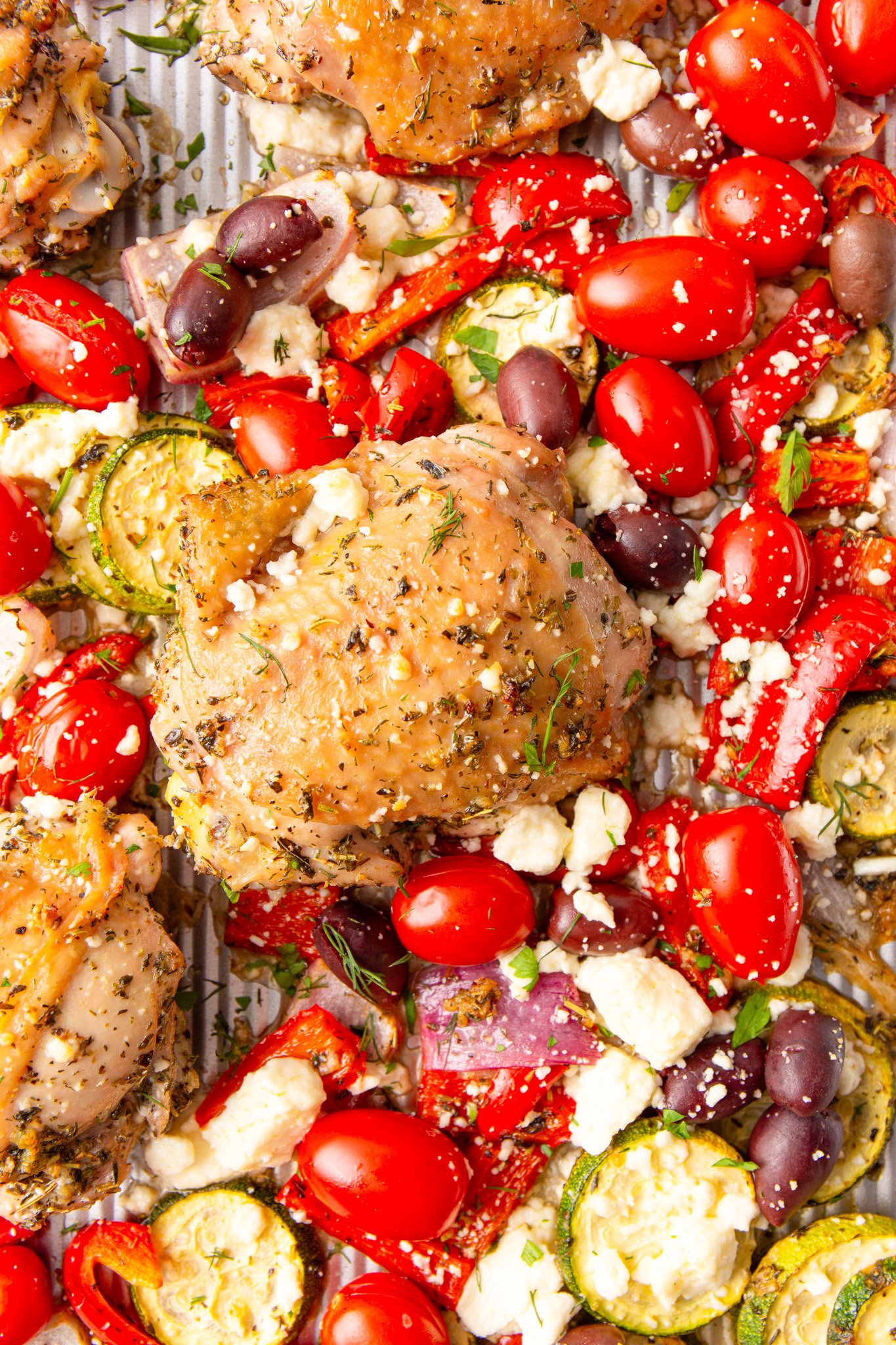 Mediterranean Sheet Pan Chicken with fresh herbs on a baking sheet. 