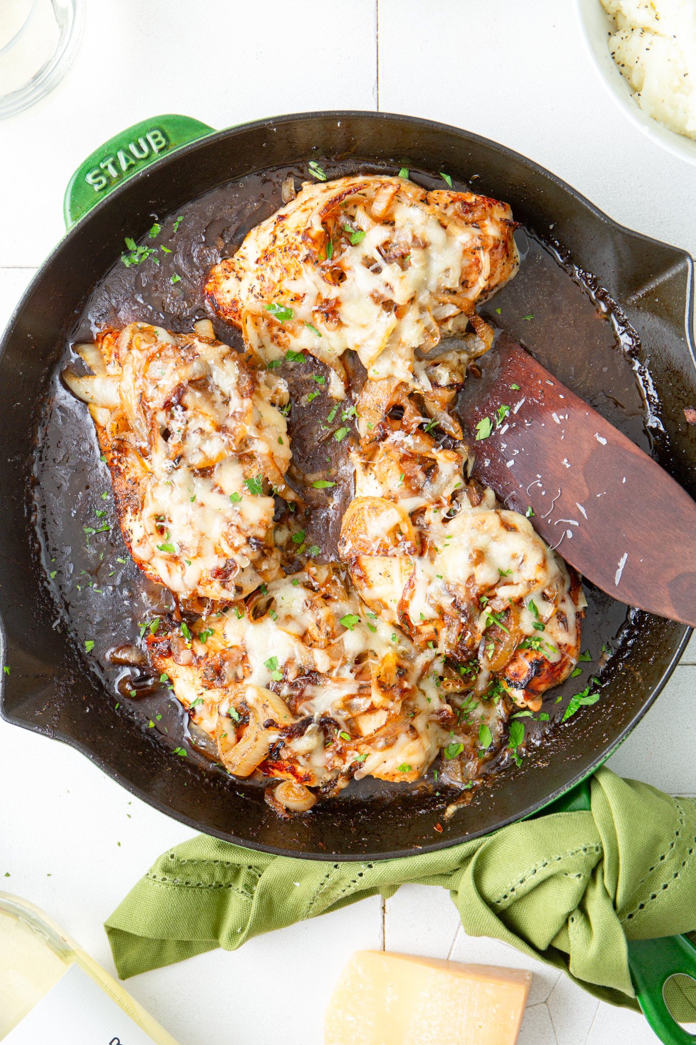 French Onion Chicken chicken in skillet with wooden spatula 