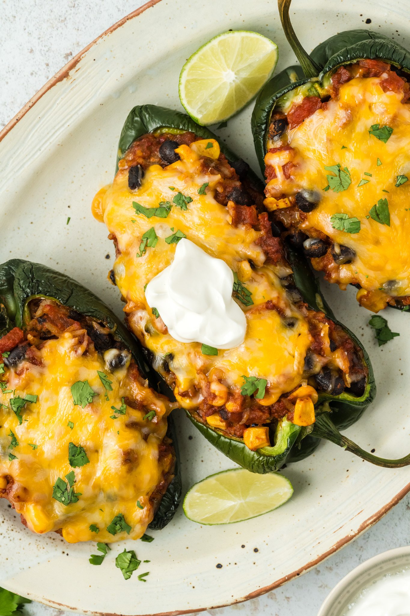 Stuffed Poblano Peppers Recipe with sour cream on platter.