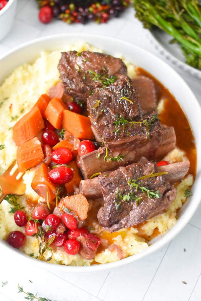 Cranberry Braised Short Ribs Recipe with fresh herbs and cranberries.