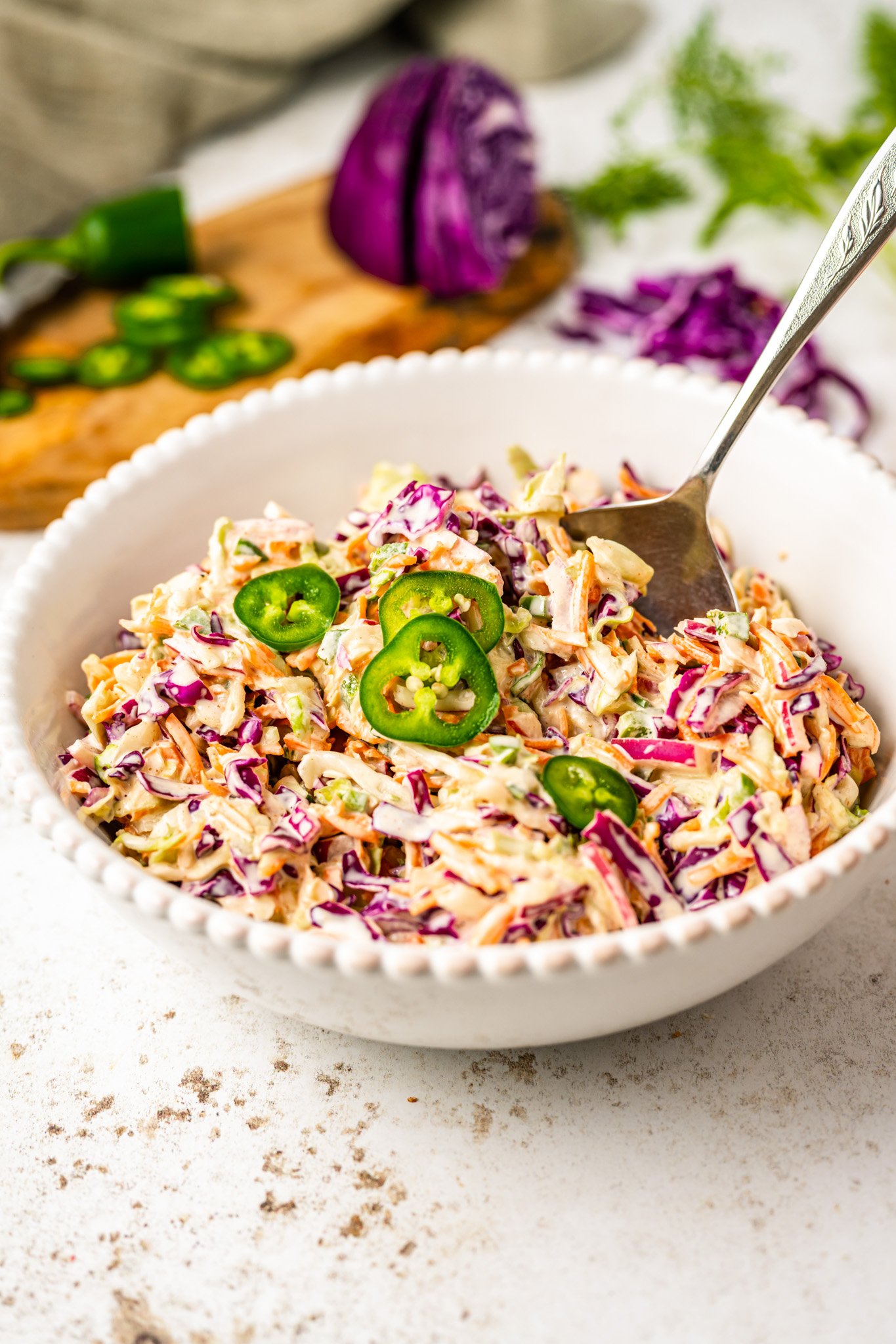 Jalapeno Coleslaw Recipe in a white bowl with a fork.