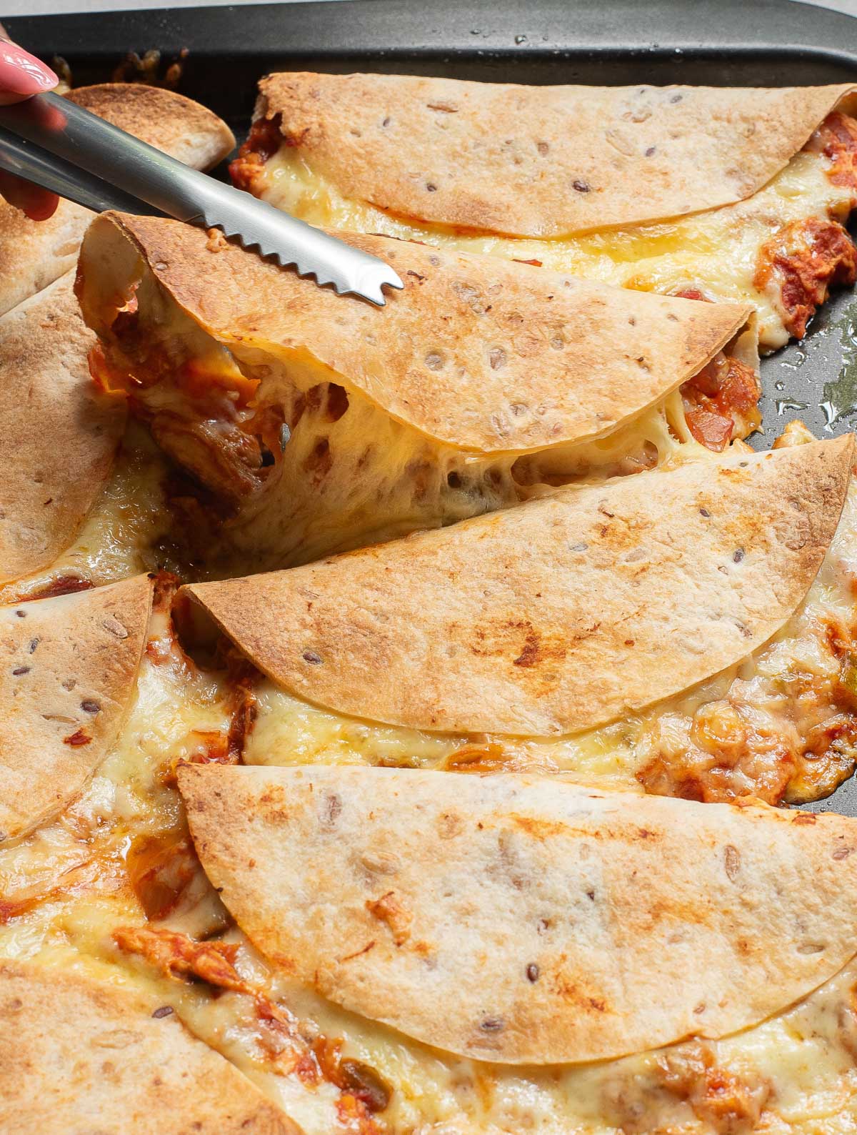 Baked Chicken Tacos with tongs 
