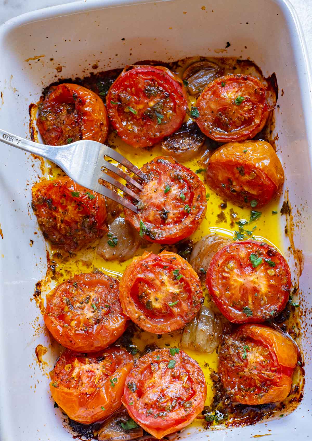 Oven Roasted Tomatoes in a pan with a fork. 
