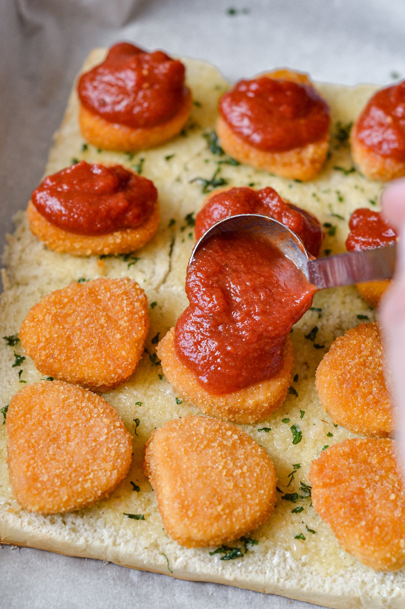 Easy Chicken Parmesan Sliders with sauce going on chicken