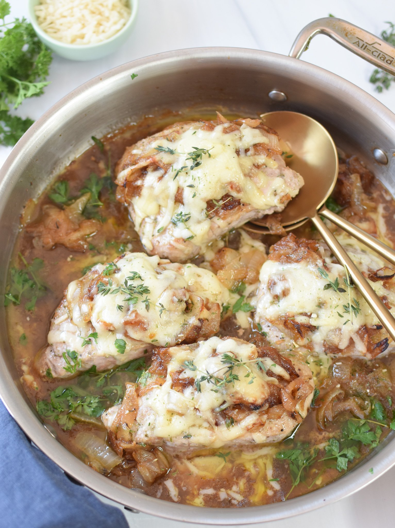 French Onion Pork Chops with gold serving spoons 