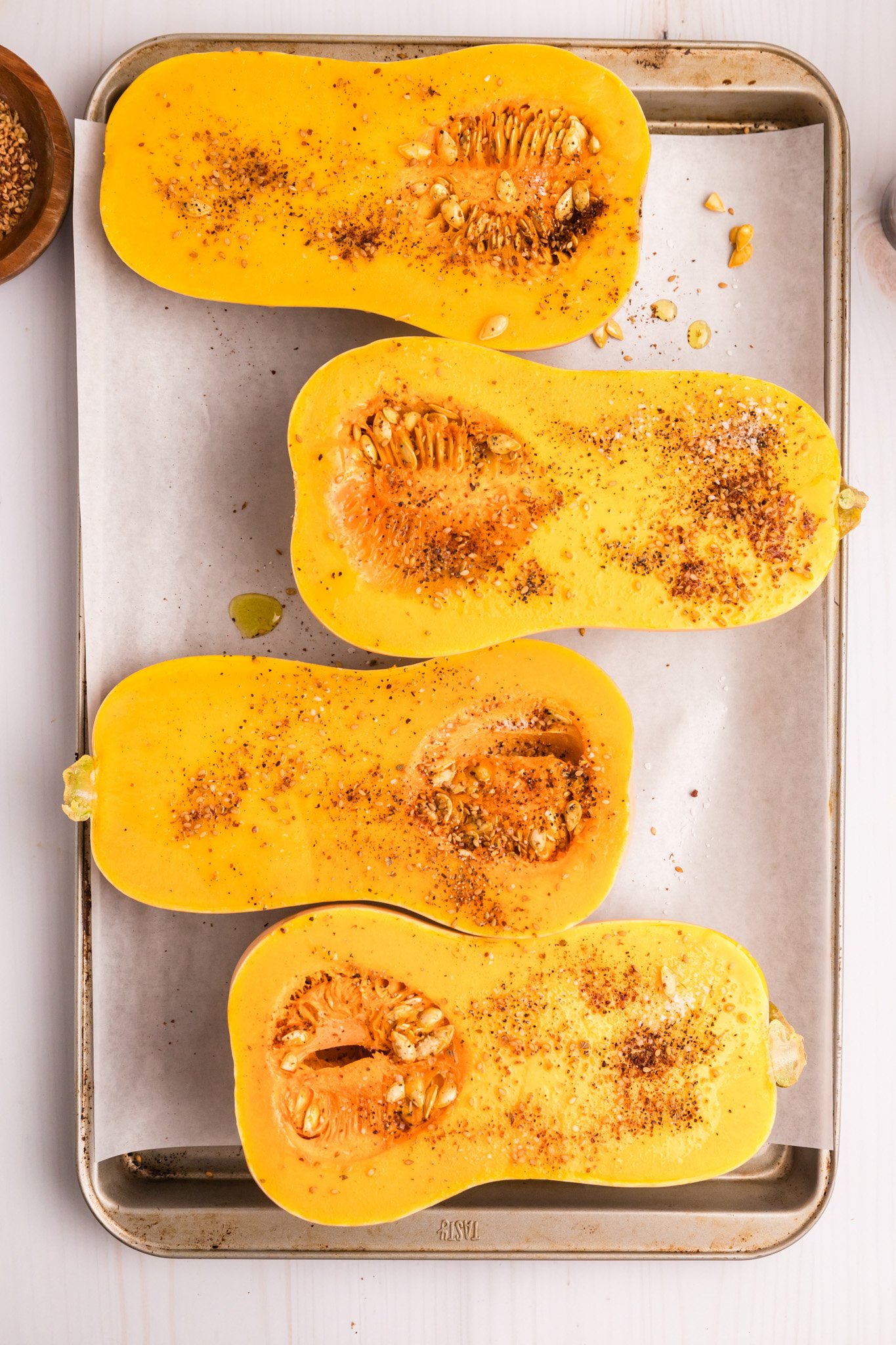Mediterranean Stuffed Butternut Squash cut open squash on a baking sheet 
