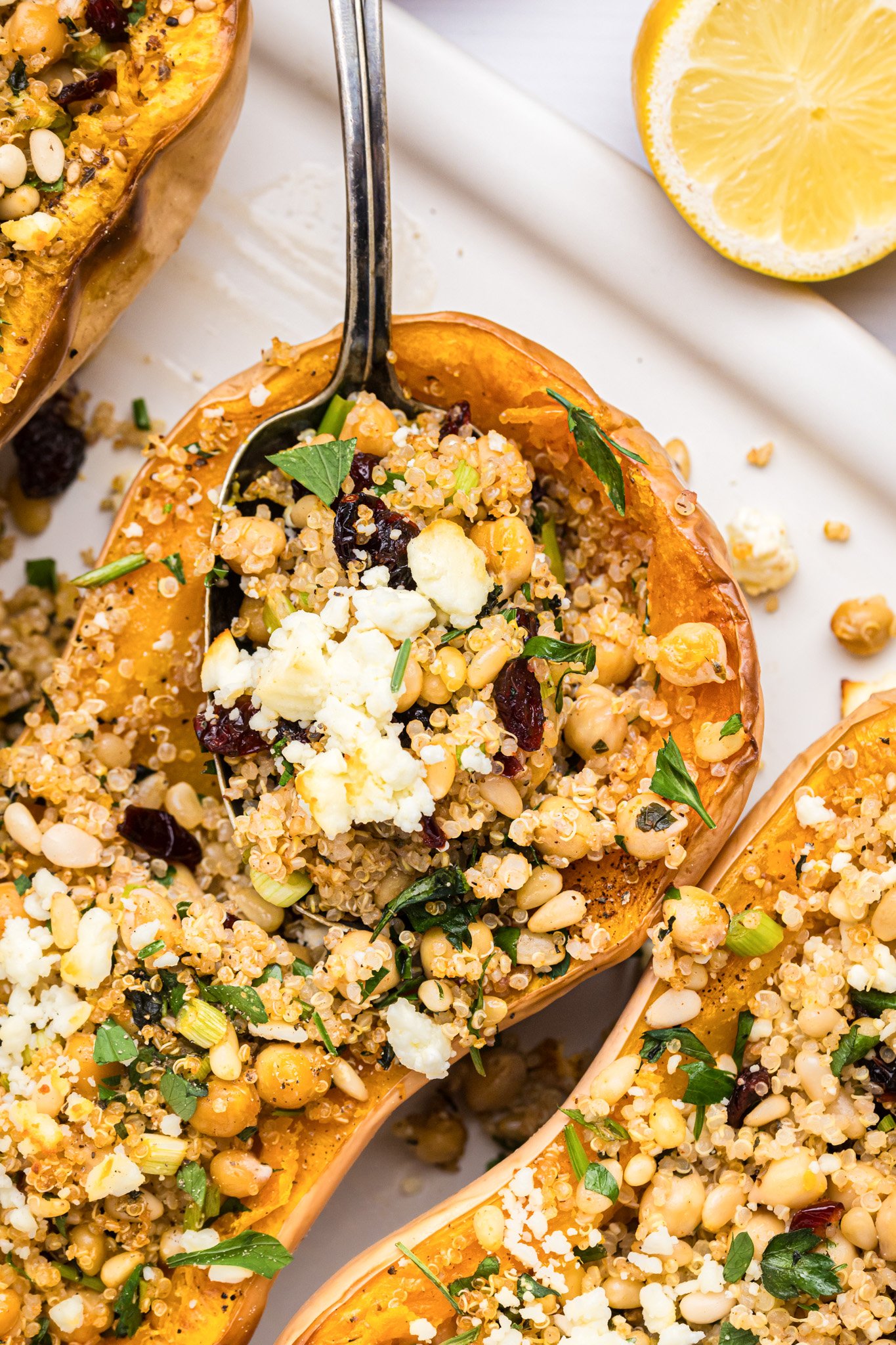 Mediterranean Stuffed Butternut Squash with spoon on a baking sheet 