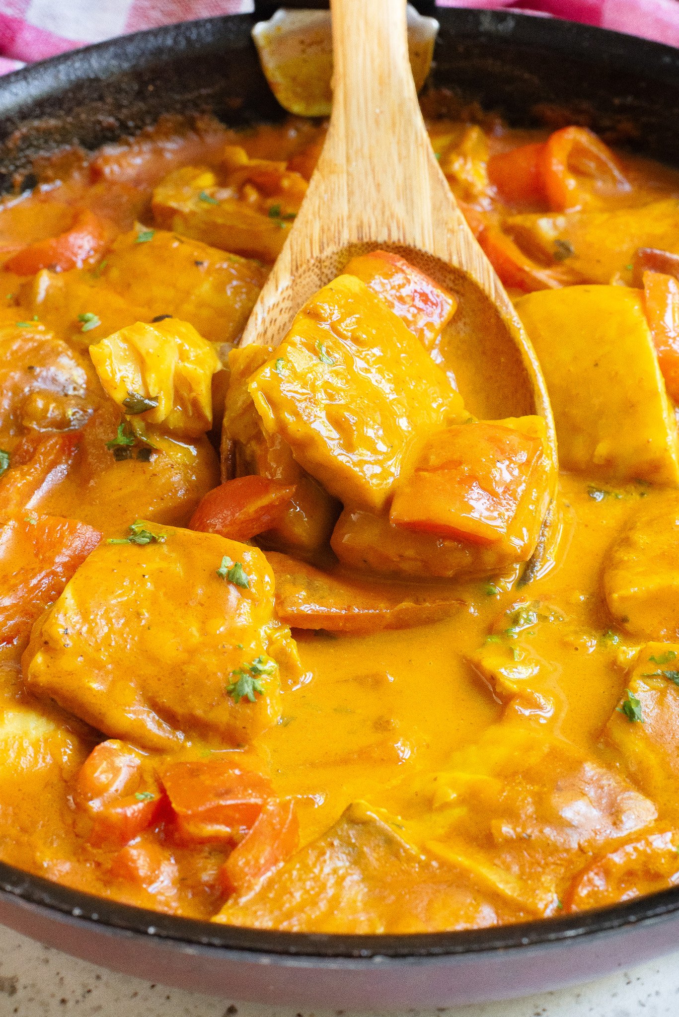 Coconut Fish Curry in skillet with spoon 