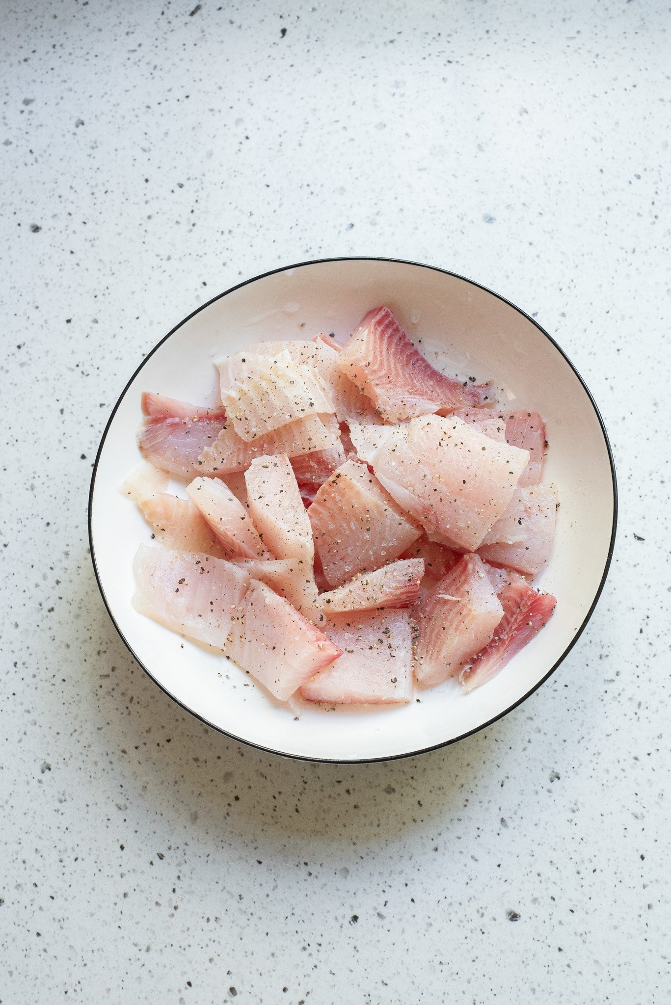 Coconut Fish Curry raw fish in a white bowl 