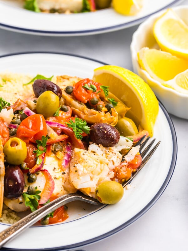 Mediterranean Baked Fish on a white plate with fork